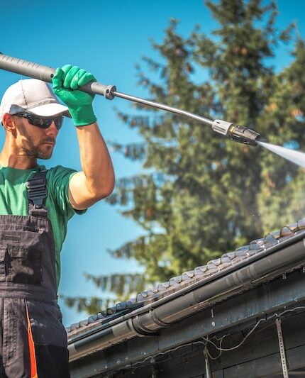 Man som rengör tak med högtryck